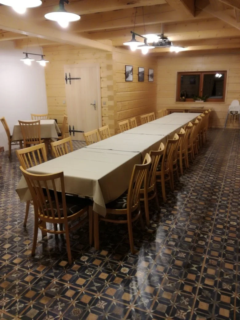 Společenská místnost se zděným krbem a dřevěnými trámy